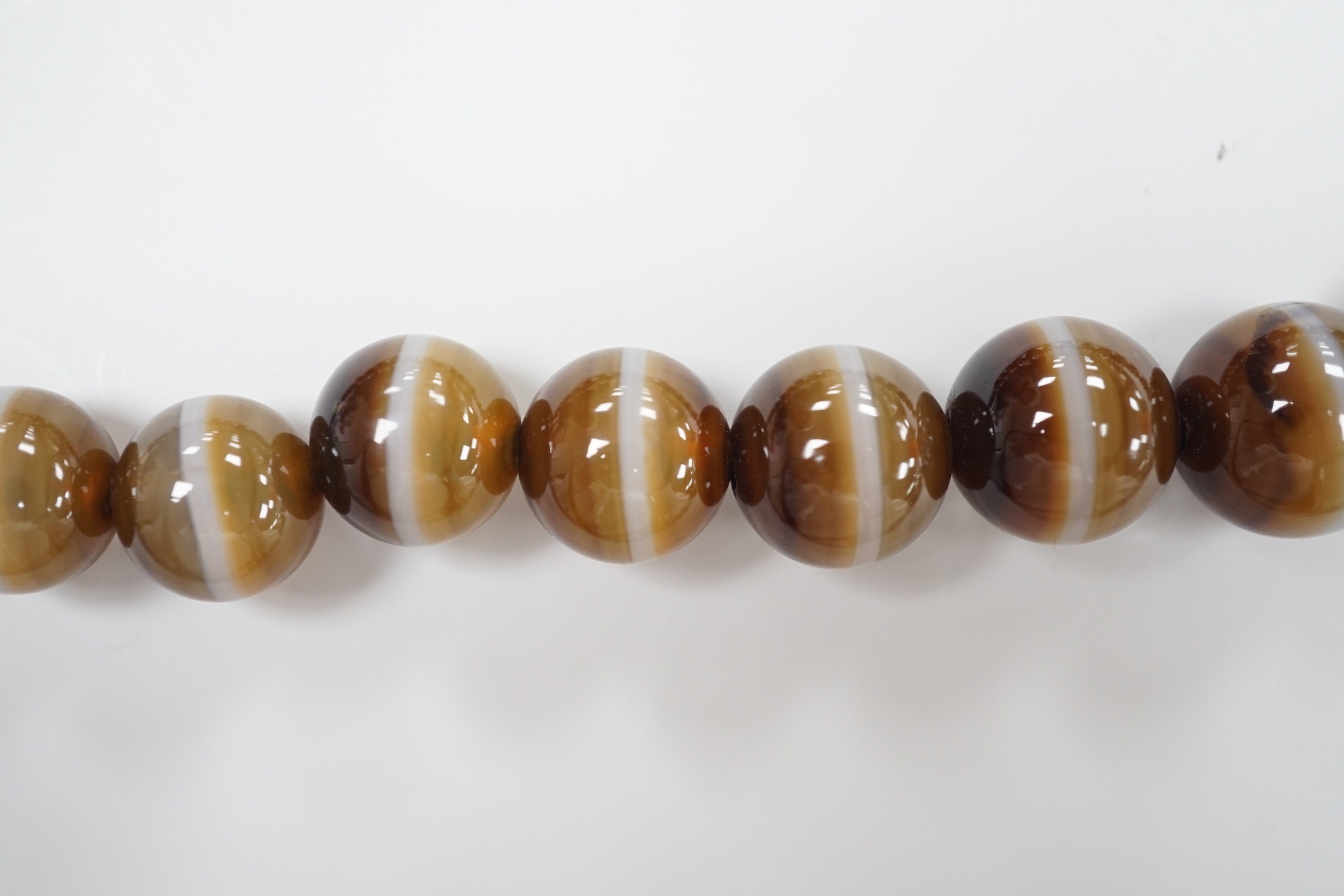 A single strand graduated banded agate circular bead necklace with yellow metal clasp, 46cm.